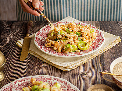 Kesespätzle Tofu-Geschnetzeltes mit Lauch auf Tellern und geriebenem Käse.