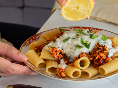 Türkische Pasta mit Tofu Pasta mit Tofugeschnetzeltem und Joghurt mit Zitrone und Tischdekoration.