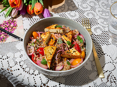 Dinkel Salat mit Koriander Limetten Tofu Bunter Salat mit Tofu auf einem Tischtuch mit Dekoration.